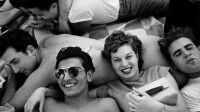 Several teenagers recline on a Coney Island beach, New York, 1949.